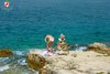 Rovinj Golden Cape girl sunbathing on rocky beach